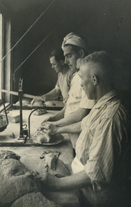 827323 Afbeelding van medewerkers van bakkerij J.W.A. Mulder (Dorpstraat C8) te Harmelen, tijdens het vormen van de broden.